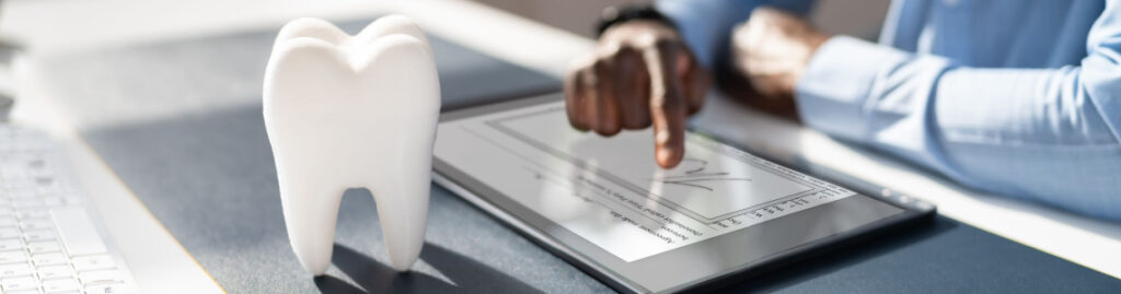 Man making calculations with a tooth on his desk